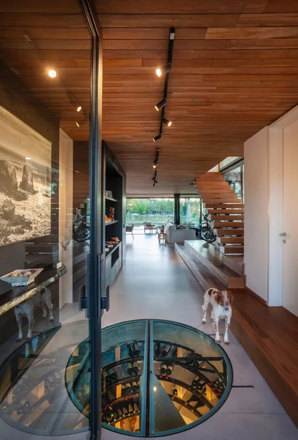 Moderna casa con cava de vino vidriada y techo de madera — proyecto Muelles - Estudio Pacifica, por ABEJA CONCEPT, en Nordelta